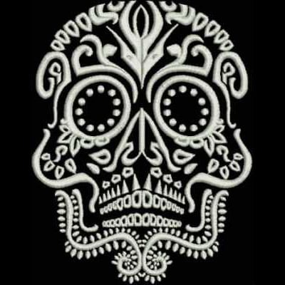 An embroidery design of a decorative skull featuring intricate patterns and embellishments in a monochromatic style.