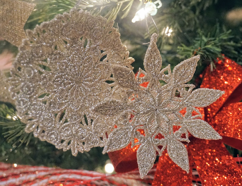 An embroidery design of two intricate gold snowflake ornaments featuring detailed patterns.