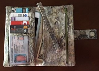 An embroidery design of a stylish wallet featuring various compartments for cards and cash.