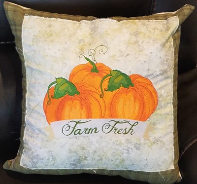 An embroidery design of vibrant orange pumpkins with green leaves, accented by a banner that reads "Farm Fresh."