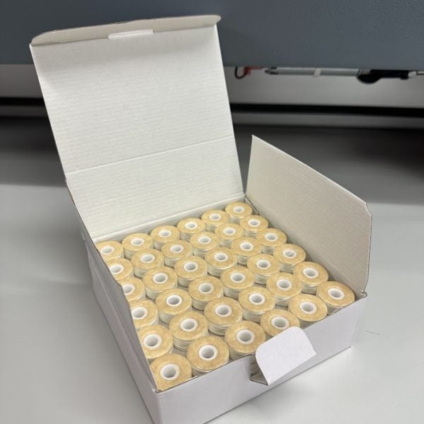 An embroidery design of a neatly arranged box containing multiple spools of thread.