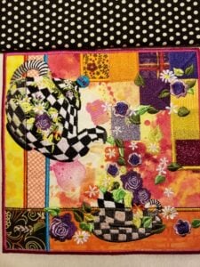 An embroidery design of whimsical checkered teapots adorned with vibrant floral accents and colorful patchwork elements.