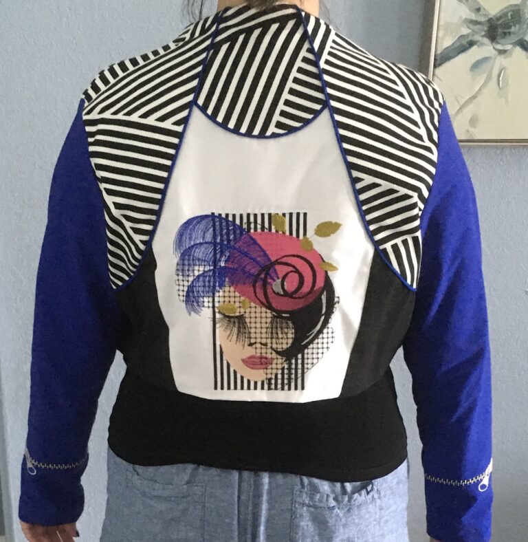 An embroidery design of a stylish woman’s face adorned with a colorful hat and striking makeup, surrounded by bold black-and-white stripes.